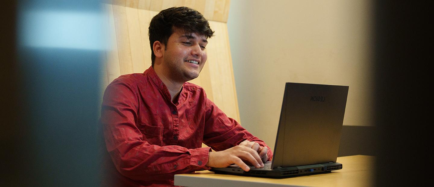 A young man working at a laptop